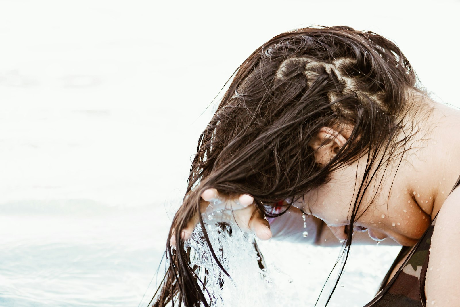 A woman rinsing her long hair